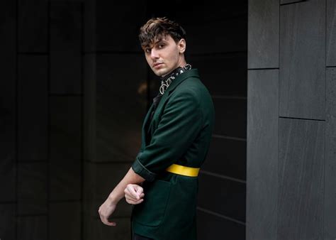 Urban portrait of non binary person in green jacket | Free Photo