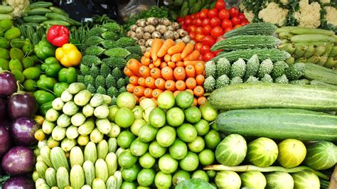 Colorful assortment of organized fruits and vegetables at market stand ...
