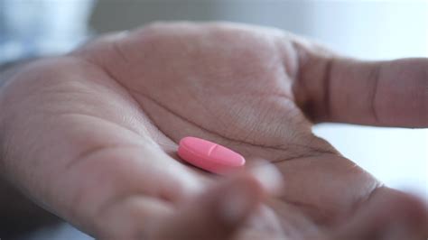 Single pink oblong pill in palm of hand 14193955 Stock Video at Vecteezy