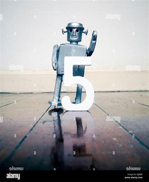 number 5 robot toy on a woden floor with reflection Stock Photo - Alamy