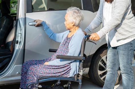 Caregiver help and support asian elderly woman sitting on wheelchair ...
