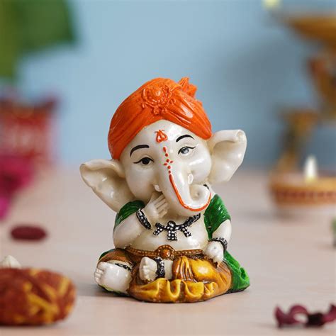 eCraftIndia Orange Polyresin Handcrafted Eating Lord Ganesha Idol whil