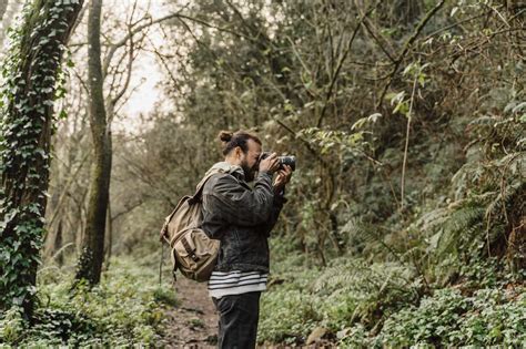 See related image detail. Young man taking pictures in the forest with his camera stock photo
