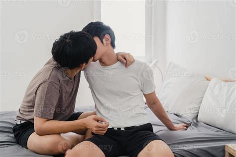 pareja gay asiática besándose en la cama en casa. jóvenes asiáticos ...