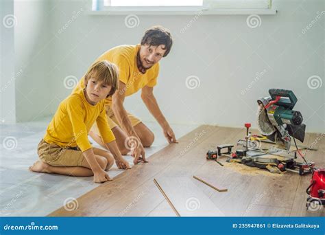 Father and Son Installing New Wooden Laminate Flooring on a Warm Film ...