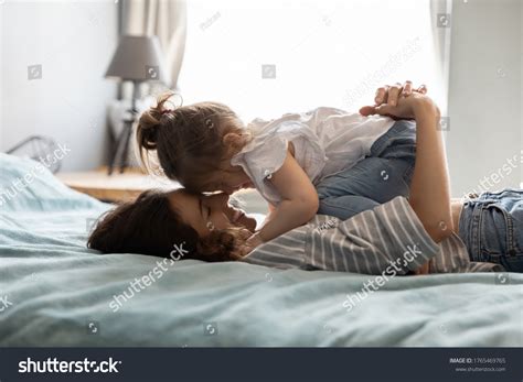 Mother and daughter cuddling on a bed in a kids room