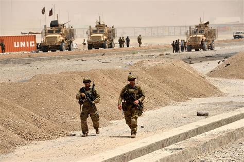 US soldiers walk at the site of a Taliban suicide attack | ESPNcricinfo.com
