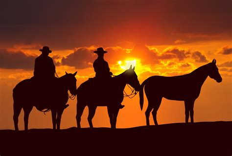 Sunset Cowboy Silhouettes: HD Horseback Serenity Wallpaper