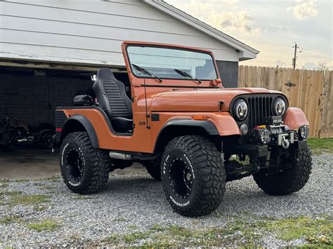 Orange Jeep CJ5 Parked in Front of Garage