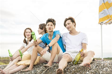 坐在海滩上聊天喝酒的青年游客高清图片下载-正版图片502034776-摄图网