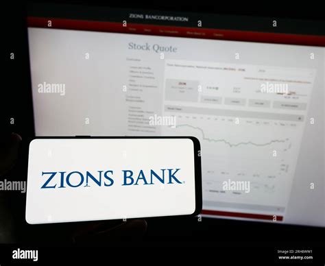 Person holding mobile phone with logo of US banking company Zions ...
