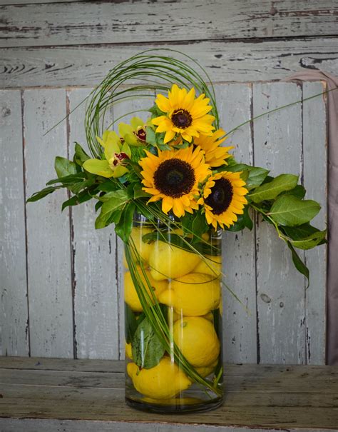 Citrus is in! Lemons, sunflowers and orchids with bear grass in a ...
