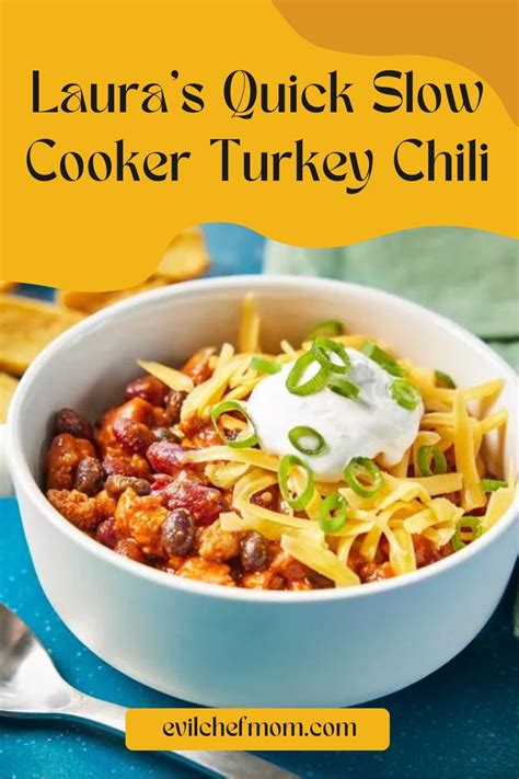 A bowl of Laura's quick slow cooker turkey chili, topped with shredded cheese, sliced green onions,