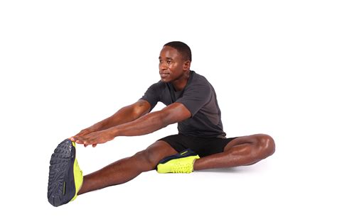 Fitness man stretching legs sitting down