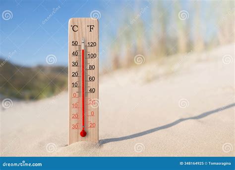 Wooden Celsius and Fahrenheit Scale Thermometer in the Sand. Ambient ...