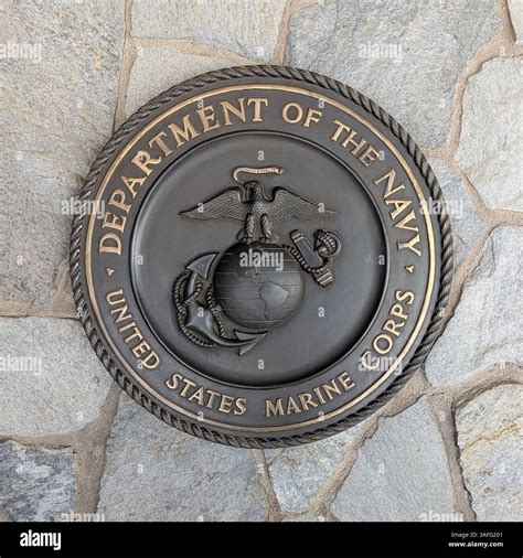 Bronze plaque of US Marine Corps emblem or crest on natural stone wall ...