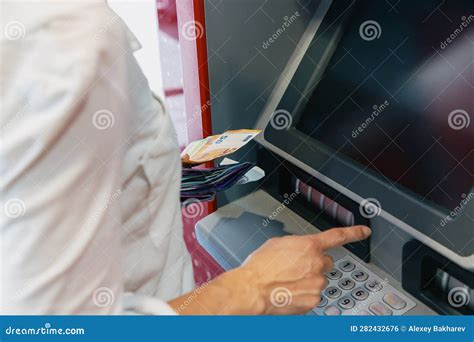 A Woman Deposits Money into Her Account Using a Street ATM. Stock Photo ...