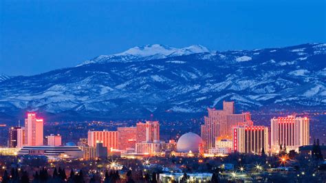 City skyline of Reno, Nevada, featuring illuminated casinos and snowy mountains in the background, representing local geography for Managed IT Services marketing.