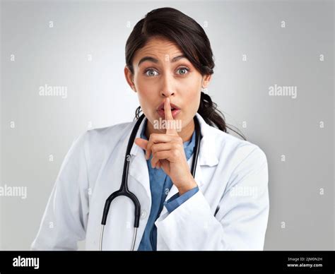 Dont ask, dont tell. Studio portrait of a young doctor with her finger ...