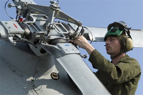 Tightening the tail rotor blades of an SH-60B Sea Hawk helicopter ...