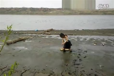 女子穿胶马靴走向河边,深陷烂泥