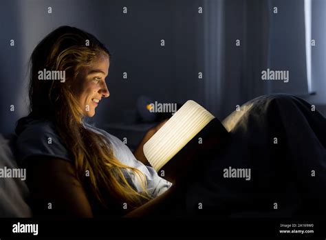 Woman reading in The Ritz-Carlton bed at a hotel