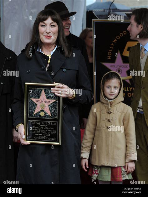 Actress Anjelica Huston (L), holds a replica plaque as her family, brother Danny Huston, rear ...
