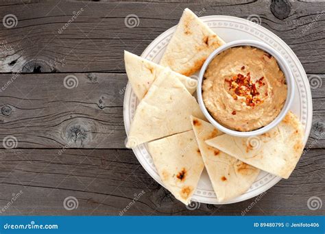 Hummus with Pita Bread on a Plate, Above View Over Wood Stock Image ...