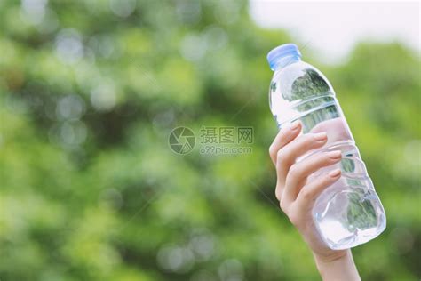 手握着从公园塑料中取出的淡水瓶在公园里美丽的花运动型高清图片下载-正版图片307910278-摄图网