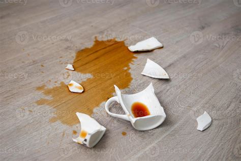 A broken cup of coffee fell on laminate, coffee spilled on floor ...