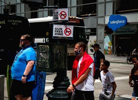 New York :Passersby walk past gun-free zone signages near Times Square ...