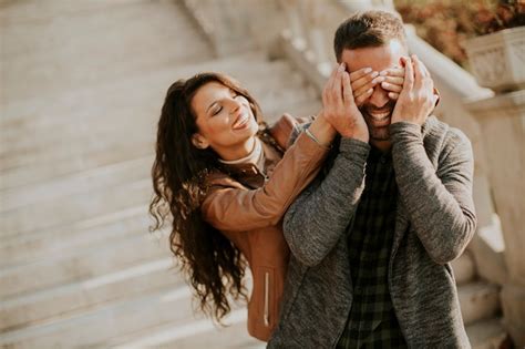 Young man covering the eyes of his girlfiend in the park | Premium Photo