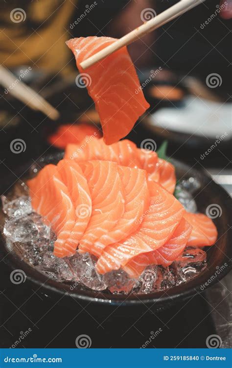 Hands Use Chopsticks To Hold the Salmon Sashimi Stock Photo - Image of ...