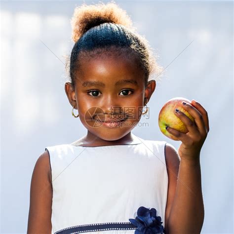 手握苹果的可爱非洲女孩的近距离肖像在光背高清图片下载-正版图片502515000-摄图网