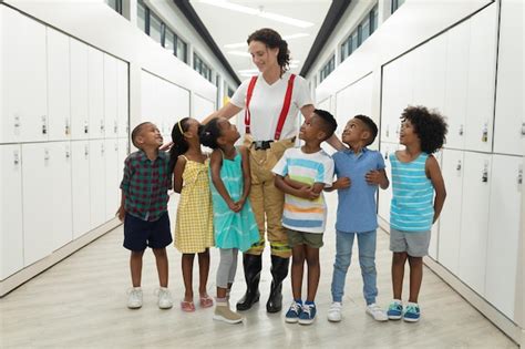 Smiling caucasian young female teacher with african american elementary ...