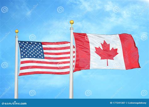 United States and Canada Two Flags on Flagpoles and Blue Cloudy Sky ...