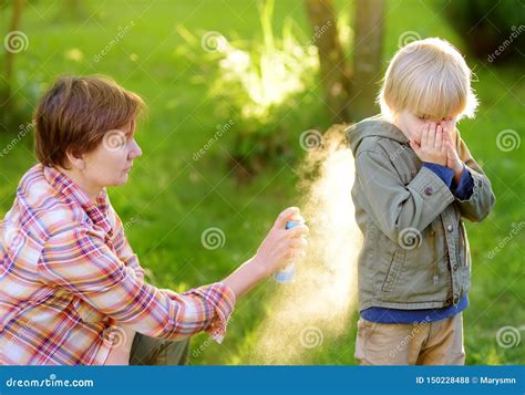 Woman Spraying Insect or Mosquito Repellents on Little Boy before a ...