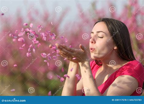 Woman Blowing Flower Petals To the Air in a Field Stock Photo - Image ...