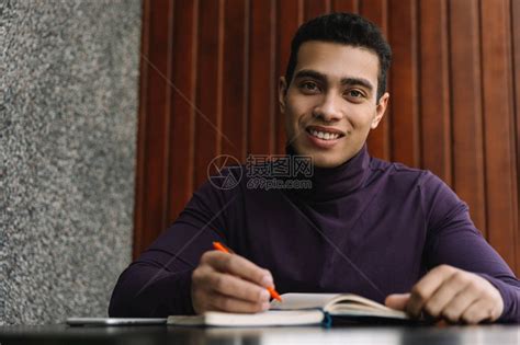 微笑的非洲裔美国大学生习学习英语在笔记本上记笔工作项目高清图片下载-正版图片505841727-摄图网