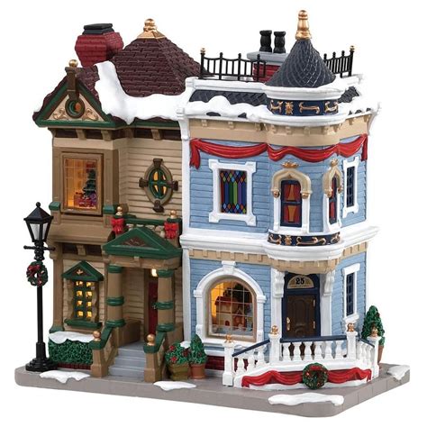 a toy house with lights and decorations on the front, snow covered roof ...