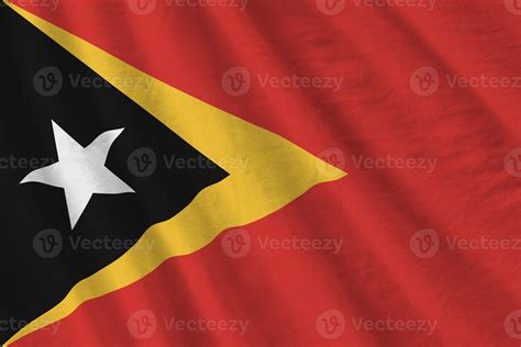Timor Leste flag with big folds waving close up under the studio light indoors. The official ...