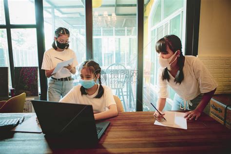 身戴保护面罩的亚裔青少年群体在家中客厅工作职的活兄弟高清图片下载-正版图片307713459-摄图网