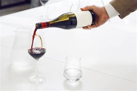Expert sommelier pouring red wine to glass close up indoor photo ...