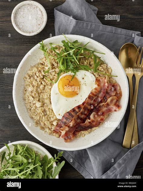 Oatmeal, fried egg and fried bacon. Brutal man sport breakfast. Hearty ...