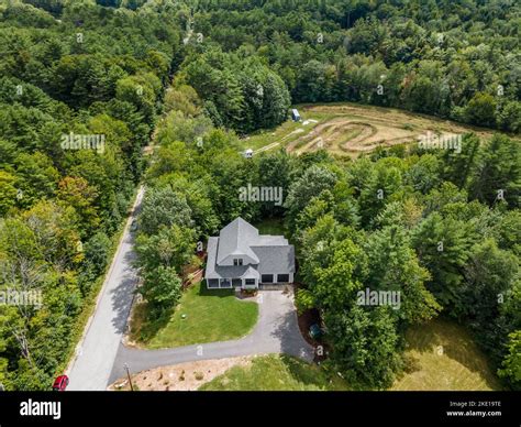 An aerial view of a forest with a modern custom new England colonial ...