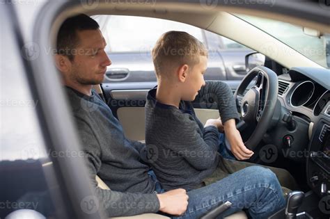 Dad shows his little son how to drive a car 21033939 Stock Photo at Vecteezy