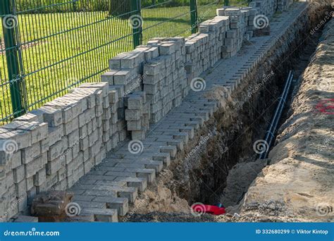 Construction Work on a Brick Wall Expanding Alongside a Trench for ...