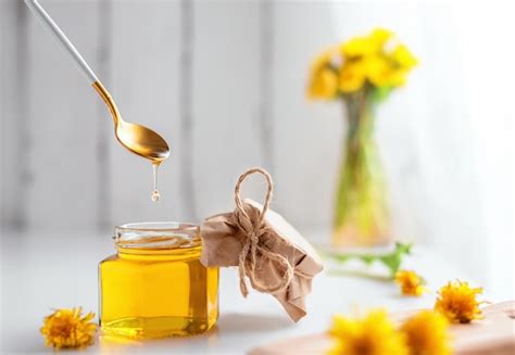 Dandelion honey in a jar and fresh flowers | Premium Photo