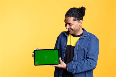 Young male model being joyful and pointing at isolated chroma key on ...