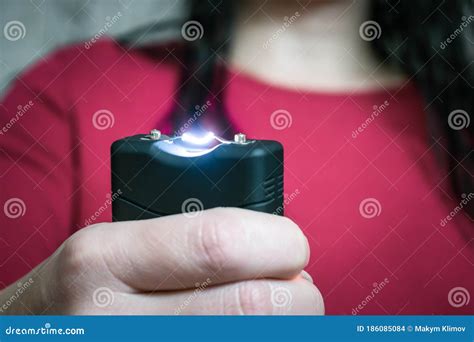 The Girl Holds a Personal Taser in Her Hands To Protect Against Bandits ...